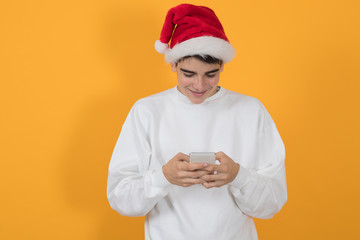young teenage man with christmas hat isolated on color background
