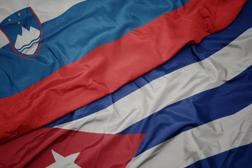 waving colorful flag of cuba and national flag of slovenia.