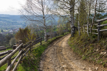 Carpathian mountains. Country road between rural log fences.