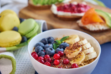 breakfast top view black background. oatmeal with berries, toasts on a wooden tray, nuts, coffee