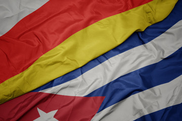 waving colorful flag of cuba and national flag of south ossetia.