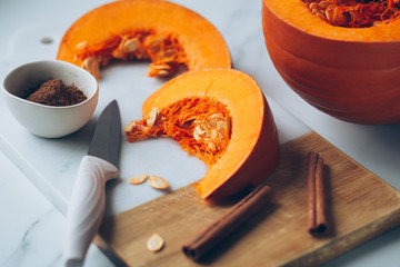pumpkins with cinnamon sticks on marble backgrund