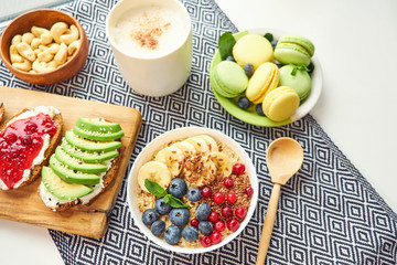 breakfast top view isolate white background. oatmeal with berries, toasts on a wooden tray, nuts, coffee