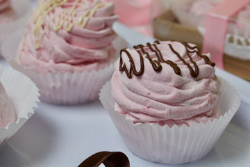 Aerial pink cherry marshmallows. Different shapes and sizes. Sprinkled with dextrose. Garnished with Chocolate.
