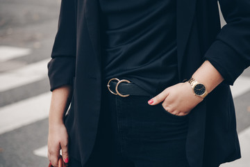 street style 2019 fashion details. close up, young fashion blogger wearing black jeans, satin top,...