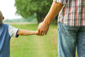 the parent holds the hand of a l child