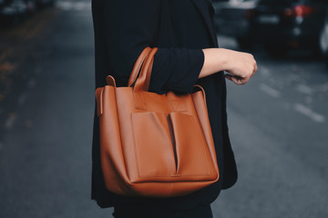 street style 2019, attractive woman wearing a satin top, black blazer and a tan brown tote bag,...