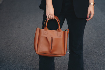 street style 2019, attractive woman wearing a satin top, black blazer and a tan brown tote bag,...
