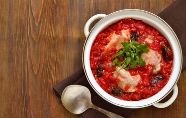 Chicken in spicy tomato sauce with dates, top view, copy space