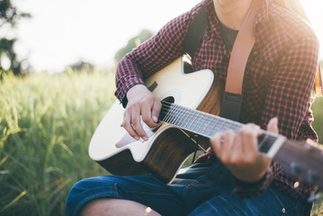 Country music, Man playing acoustic guitar in rice field, Focus on the right hand, Close-up