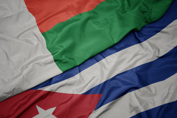 waving colorful flag of cuba and national flag of madagascar.