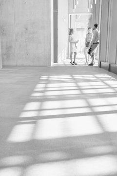 Black And White Photo Of Business People Discussing Plans Before Meeting