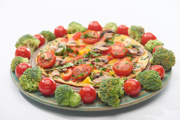homemade omelet on plate with fresh tomatoes and broccoli