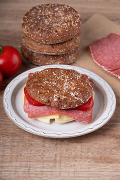 Round rye bread roll with cheese and salami