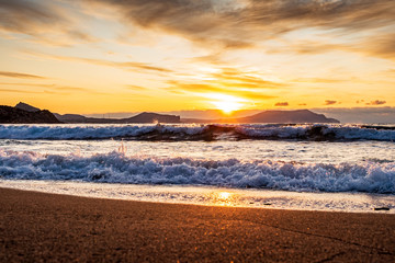 picturesque sunrise over the Black Sea, waves roll on the sand