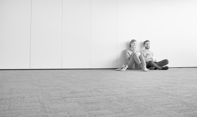Black and white phoyo of business people sitting on the floor during break in office