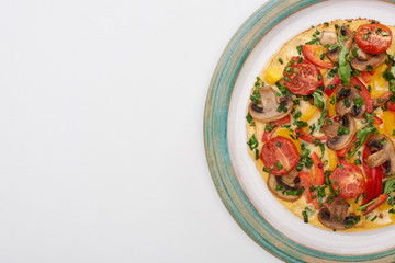 top view of plate with tasty omelet with tomatoes, greens and mushrooms for breakfast on white table