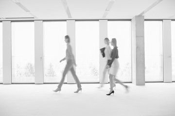Black and white photo of business people walking in office hall