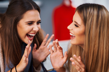 Adult women shopping for clothes in boutique in autumn