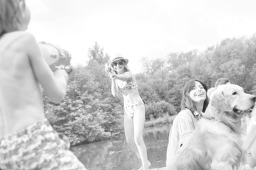 Young girl playing squirt guns with her brother on pier during summer