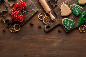 top view of Christmas cookies near viburnum and spices on wooden table
