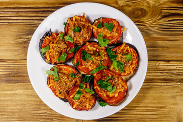 Baked eggplants with tomatoes and cheese on wooden table. Top view