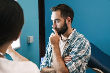 Image of female doctor and patient man looking at x-ray scan in hospital