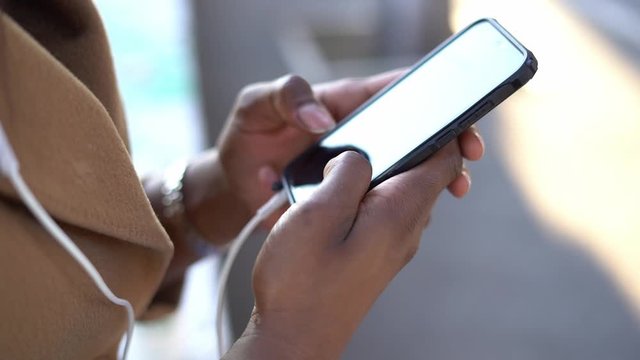 Female hands selecting song on mobile phone