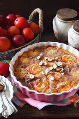 Autumn dessert. Red plums clafoutis, hazelnut and icing sugar dressing, french cuisine