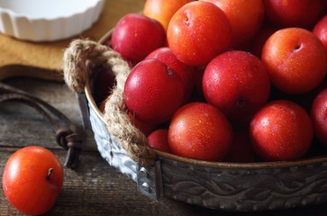 A lot of red plums in basket