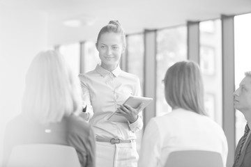 Black and white photo of Young businesswoman planning strategy with colleagues during meeting at office