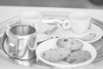 Black and white photo of  cookies and coffee on table at restaurant
