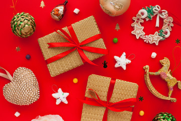 Christmas composition. Beautiful toys, gifts and candy on the red background. New year background. Top view. Close up. Space for a text.