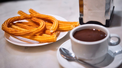 Portion of hot Madrid Churros served on a table. Close up of a plate with churro sticks ready to eat.