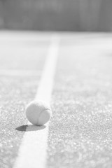 Tennis ball on red court during sunny day