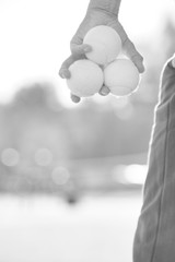 Black and white photo of  senior man holding tennis balls on court
