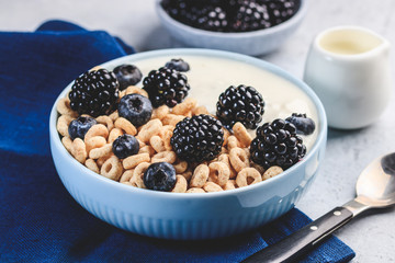 Bowl filled with corn ring cereals and berries. Healthy breakfast
