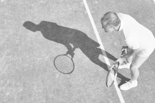 Black and white photo of senior athlete playing tennis