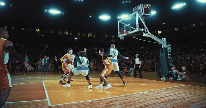 Basketball players on big professional arena during the game. Tense moment of the game. Celebration