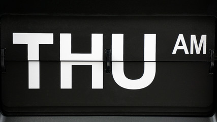 Close-up Flip clock label THU am. on Black background,Time concept..