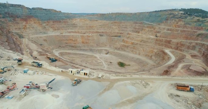 Aerial view of opencast mining quarry with lots of machinery at work - view from above.