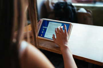 female hands work on pc tablet at the table