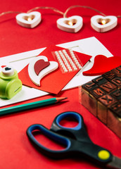 Making Greetings card concept. Various arts and crafts tools on table, red background. 