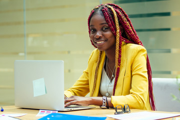 woman fashion designer with afro pigtails dreadlocks working on her atelier or print publishing...
