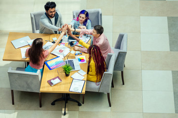 mixed-race journalist fashion designers working together in a bright office