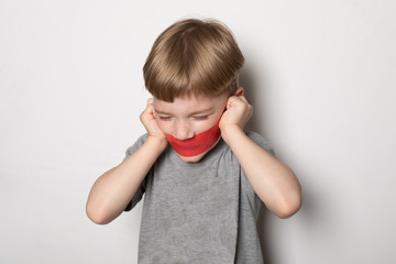 boy is afraid and does not want to go to school. Preschooler with closed mouth, eyes and ears. the boy silently screams