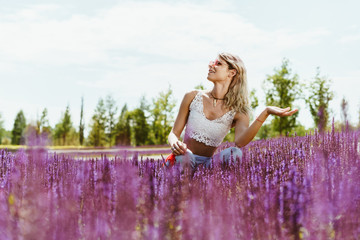 athletic girl crouched among lavender flowers and looks to the sky