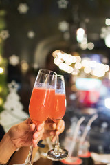 Cheers, clinking glass having a good time celebrating at party night with bokeh background.