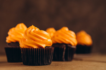 Stylish Festive cupcake and pumpkin on a dark background. sweets for the celebration of Halloween