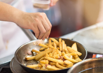 Chef is cooking french fries in the kitchen, cook preparing delicious French fries